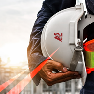 Smiling AL-SAMA site engineer wearing a branded white hard hat and safety vest