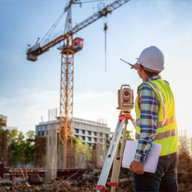 Engineer marking up construction blueprints next to a hard hat